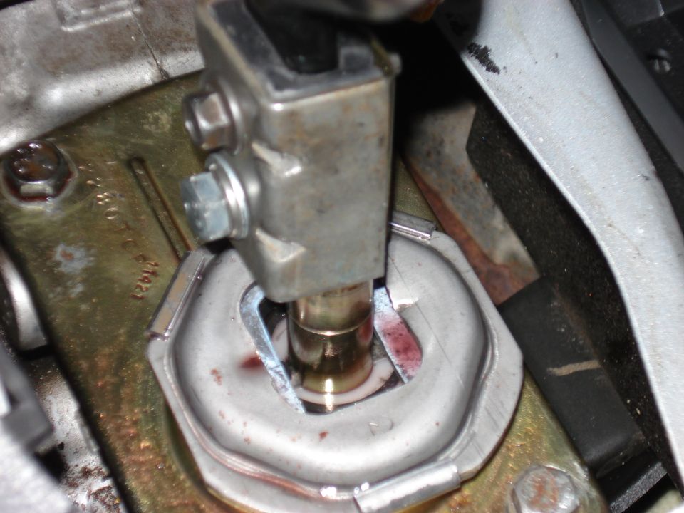 Shifter linkage mechanism with visible metal parts and red fluid