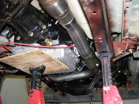 1993 Ford Bronco - Undercarriage view shows the transmission and exhaust system of a vehicle supported by jack stands.