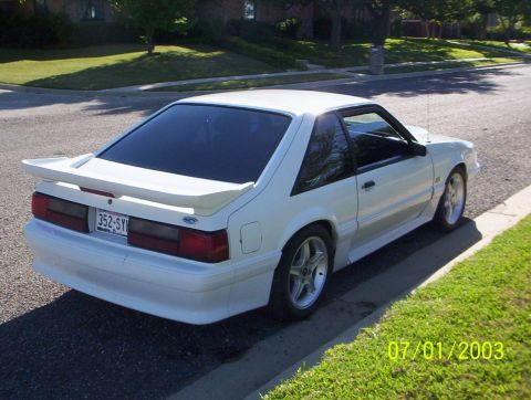 1991 Ford Mustang - Rear view of a white 1991 Ford Mustang hatchback with a spoiler.