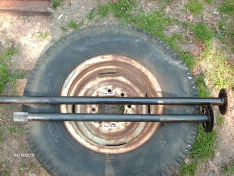 1990 Ford F-150 - Two axle shafts are displayed on top of a tire, with visible text identifying them as Dana 70HD and Corp. 14 bolt.