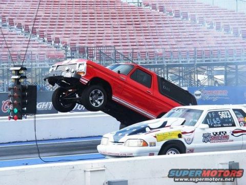 1996 Ford Bronco - Red Ford Bronco performing a wheelie at a drag strip event.