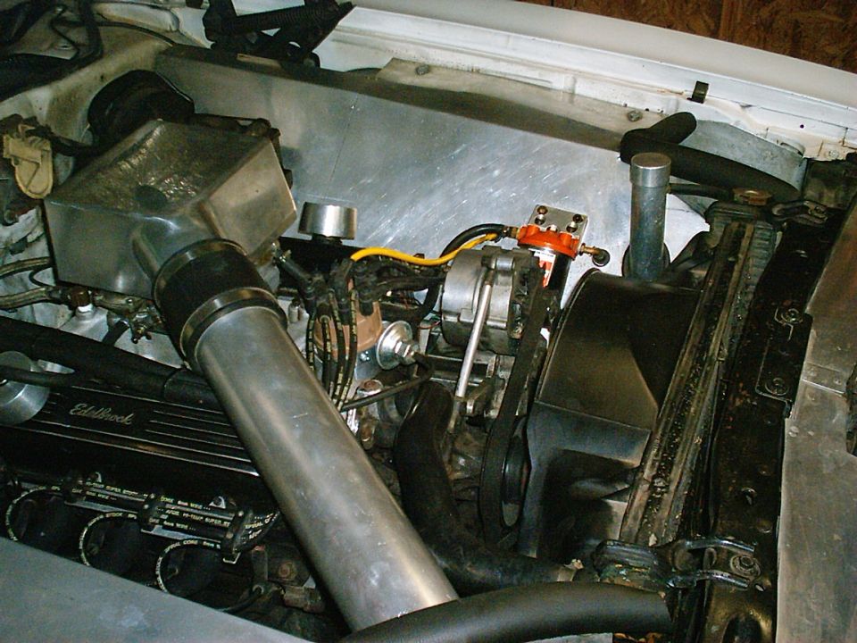 Engine bay with aluminum intake, Edelbrock valve covers, and visible alternator