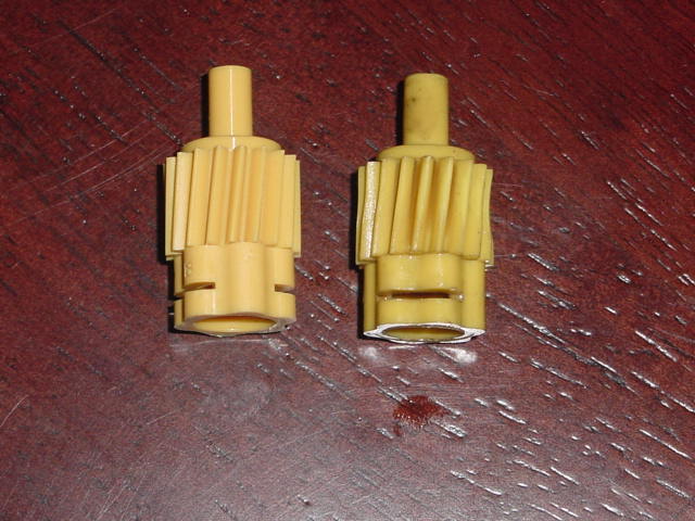 Two yellow plastic speedometer drive gears on wood surface