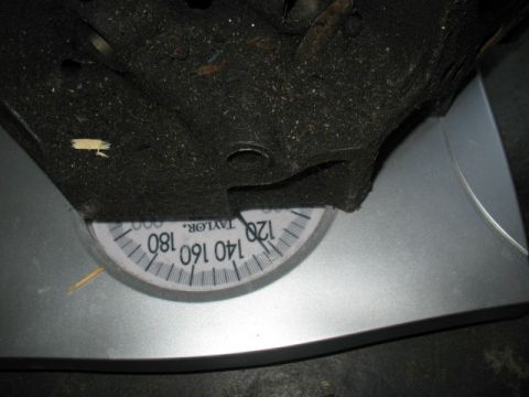 1997 Ford Crown Victoria - A car part is weighed on a mechanical scale, showing a reading around 120 lbs.