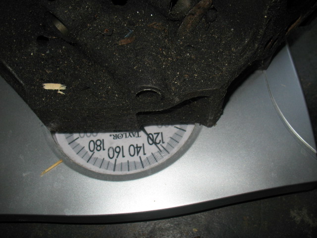 Black automotive part resting on a Taylor scale, reading approximately 120 pounds