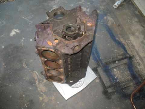 1997 Ford Crown Victoria - A rusty engine block sits on a scale in a garage.