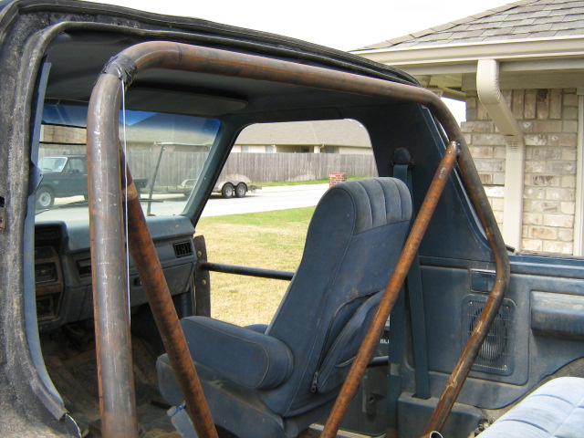 Interior view of a 1986 Ford Bronco with a custom roll cage installed around the seats
