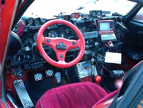 1986 Ford LTD Crown Victoria - This heavily modified interior features a bright red steering wheel, numerous aftermarket gauges, and a small screen with a keyboard.