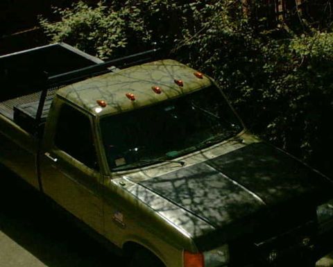 1979 Ford Bronco - A 1979 Ford Bronco truck is seen from a high angle, partially obscured by shadows and foliage.