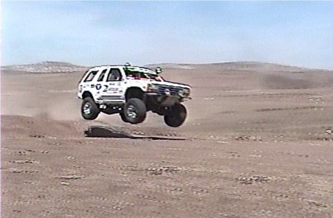 1992 Ford Explorer - A 1992 Ford Explorer is captured mid-air during a desert off-road event.