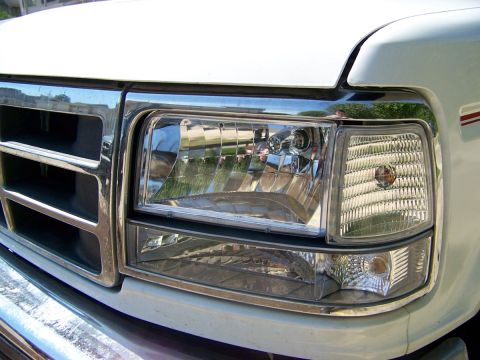 1995 Ford Bronco - Close-up of a white Ford truck's front grille and headlight assembly, indicative of a 1992 model year.