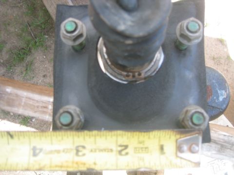 1973 Ford F-100 - A close-up view of a brake booster mounting bracket with a measuring tape for scale.