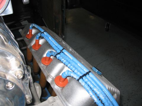 1964 Ford 427 - Close-up of blue spark plug wires and orange boots on an engine valve cover.