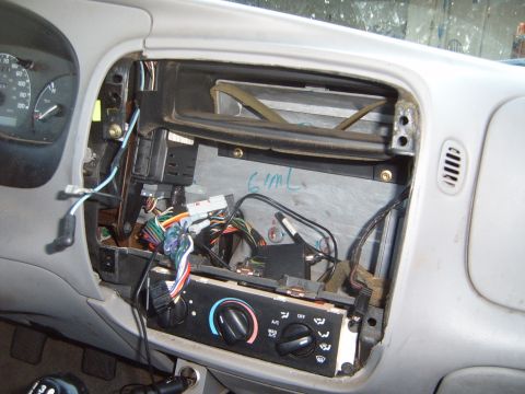 1997 Ford Ranger - The dashboard of a vehicle is disassembled, revealing the complex wiring behind the climate control and audio system.