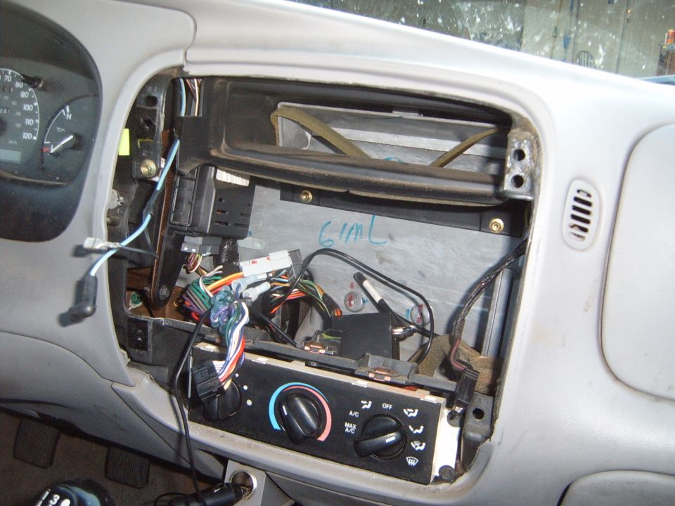 Dashboard with radio and climate controls removed, showing wiring harness and internal components