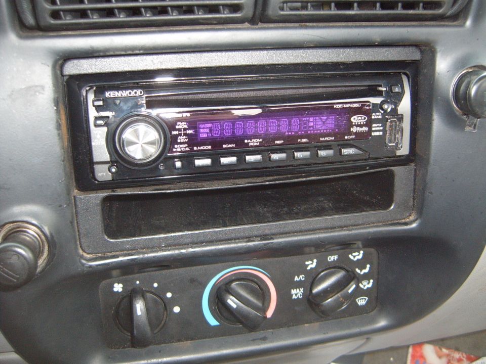 Car dashboard with Kenwood stereo and climate controls. Dusty interior