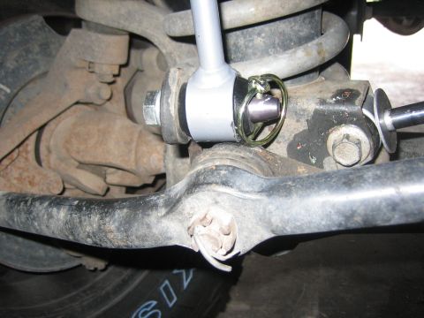 2001 Jeep Wrangler - Detail of a vehicle's suspension, focusing on the sway bar link and its securing pin.