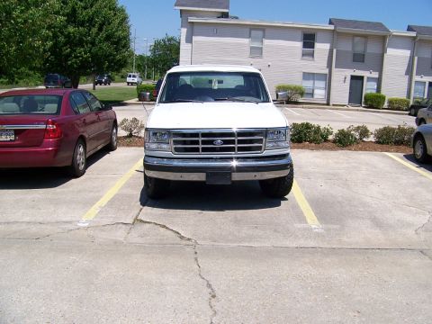 1995 Ford Bronco - Front view of a white Ford Econoline van, possibly a 1995 model based on grille design.