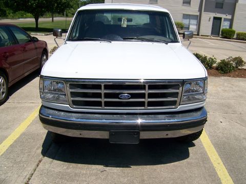 1995 Ford Bronco - Front view of a white Ford Bronco, showing its grille and headlights.