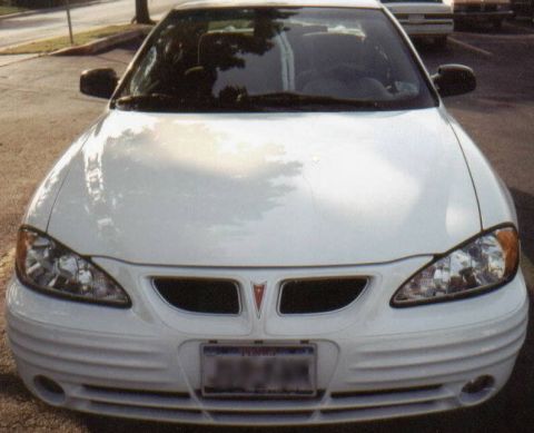 1986 Ford LTD Crown Victoria - Frontal view of a white Pontiac Grand Am, showing its distinctive grille and headlight design.