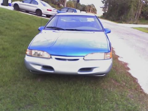 1995 Ford Thunderbird - Front view of a 1995 Ford Thunderbird with a two-tone paint job, parked on the side of a road.