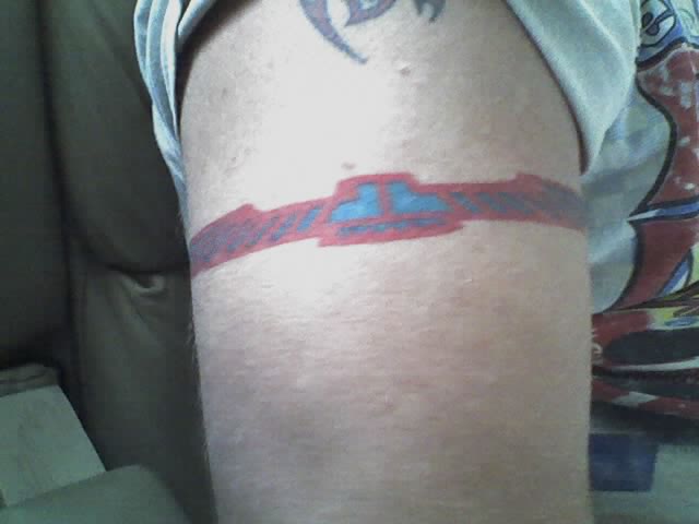 Armband tattoo in red and blue on a person's upper arm