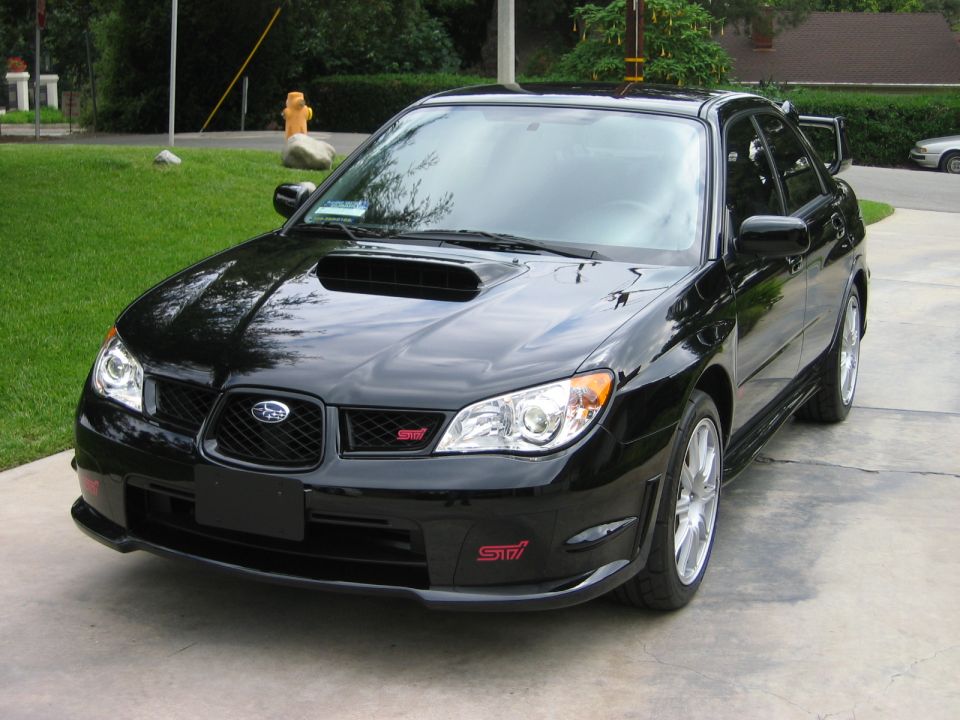 Black Subaru Impreza WRX STI, front 3/4 view. Red STI badges visible