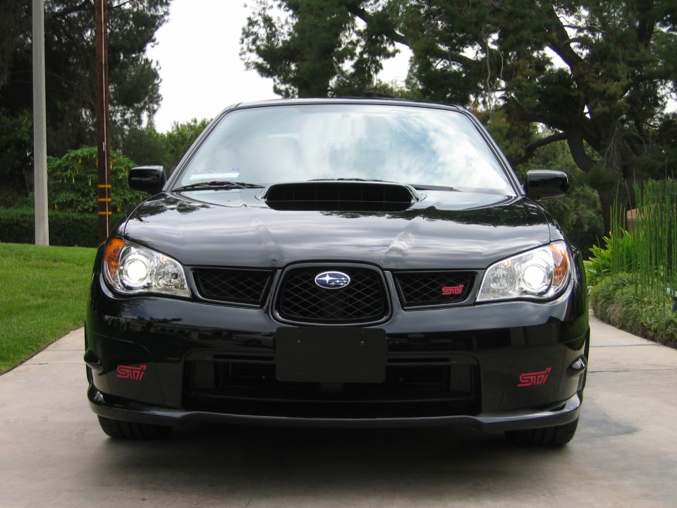Front view of a black Subaru Impreza WRX STI with red STI badges on the grille and front bumper
