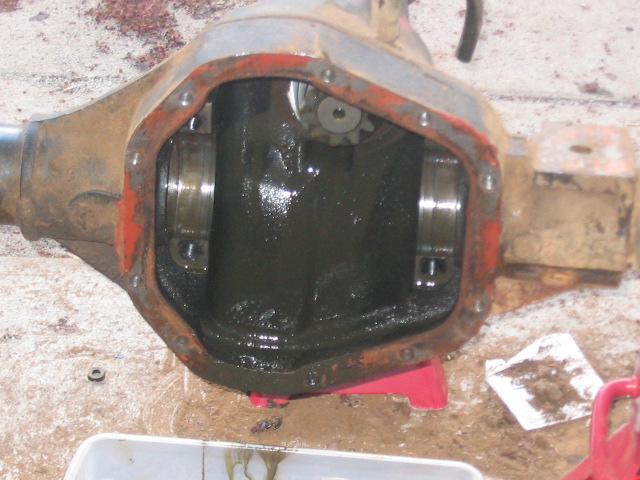 Differential housing with red paint on edges, open for inspection with dark fluid inside