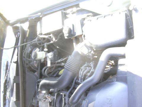 1996 Ford Crown Victoria - Engine bay of a 1996 Ford Crown Victoria, showing the air intake system and brake components.