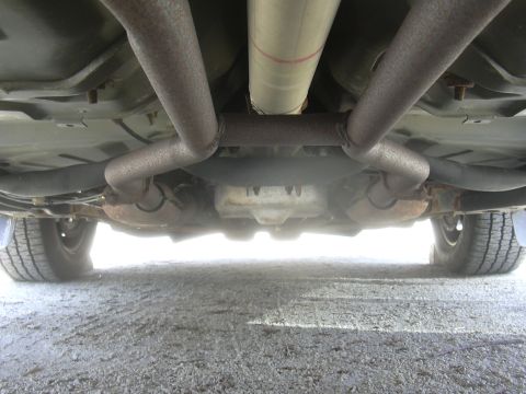 1996 Ford Crown Victoria - Underside view shows the dual exhaust pipes and driveshaft of a vehicle.