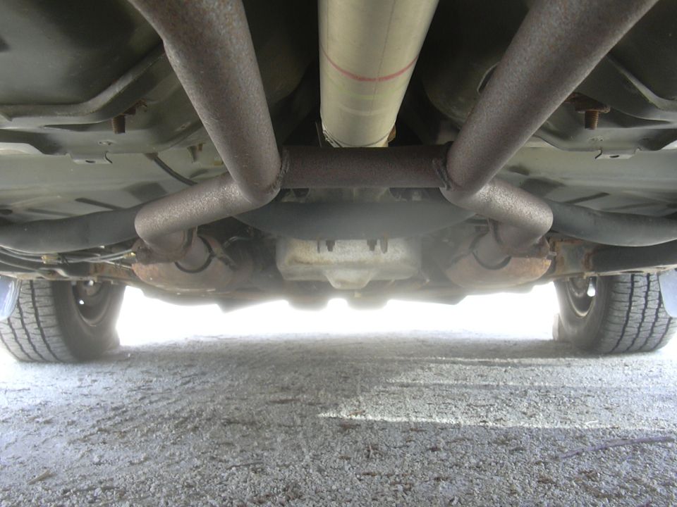 Underside view of a vehicle's dual exhaust system and driveshaft