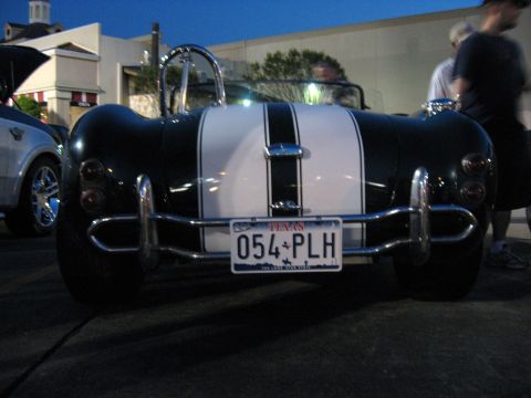 2000 Ford Crown Victoria - Rear view of a classic black sports car with dual white racing stripes and chrome bumpers.