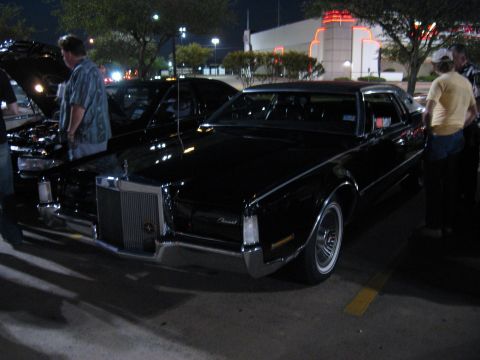 2000 Ford Crown Victoria - A black Lincoln Continental Mark V is parked at night, with people standing nearby.
