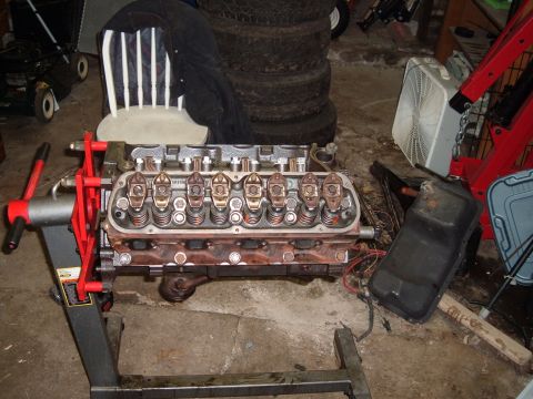 1990 Ford Ranger - Engine on a stand in a garage setting, with tires and a fan in the background.