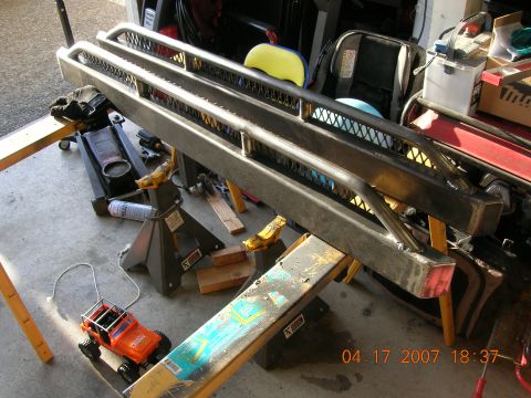 1996 Ford Bronco - Custom steel bumper assembly supported by jack stands in a garage setting.