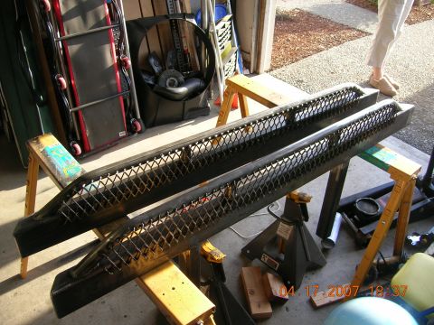 1996 Ford Bronco - Two custom bumpers are shown supported by sawhorses, with garage items in the background.