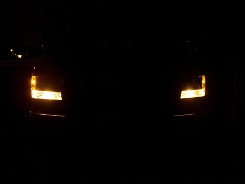 1995 Ford Bronco - Front view of a vehicle with its headlights on in the dark.