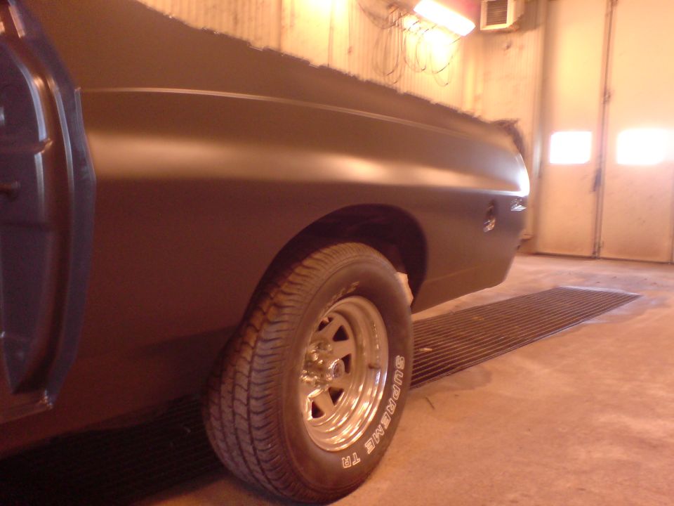 Front fender and chrome slotted wheel of a primer-gray muscle car