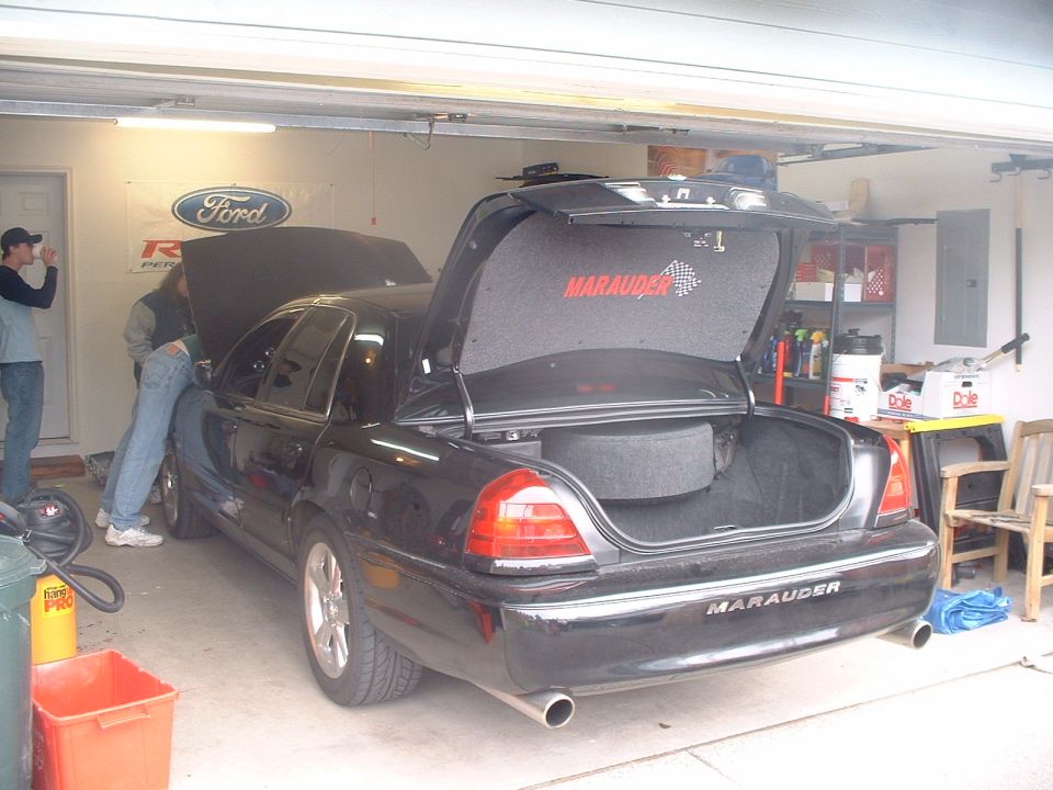 Black Mercury Marauder in garage with trunk and hood open, dual exhaust