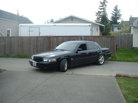 2000 Ford Crown Victoria - A black 2000 Ford Crown Victoria is parked in a driveway.