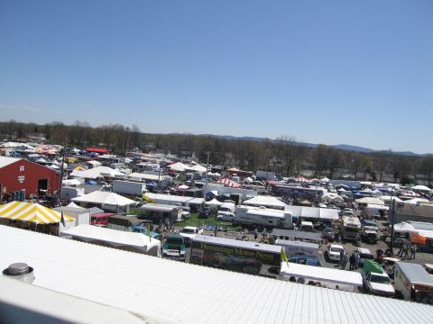 1991 Ford LTD Crown Victoria - A busy outdoor swap meet with numerous vehicles and vendor tents spread across the grounds.
