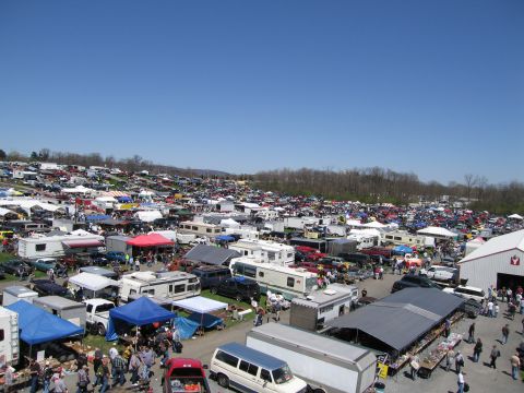 1991 Ford LTD Crown Victoria - A large outdoor gathering features numerous vehicles and vendors spread across a field on a sunny day.