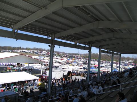 1991 Ford LTD Crown Victoria - A vast outdoor gathering of vehicles and vendors is viewed from under a covered seating area.