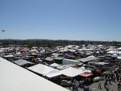 1991 Ford LTD Crown Victoria - A busy outdoor market with many vendors and vehicles spread out across the grounds.