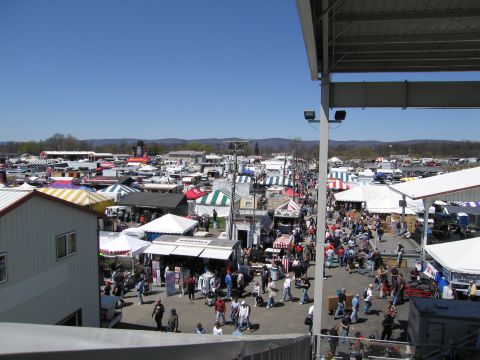 1991 Ford LTD Crown Victoria - A wide view of an outdoor market filled with tents and shoppers on a sunny day.