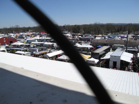 1991 Ford LTD Crown Victoria - A wide view of an outdoor market filled with tents and vehicles, suggesting a busy event or flea market.