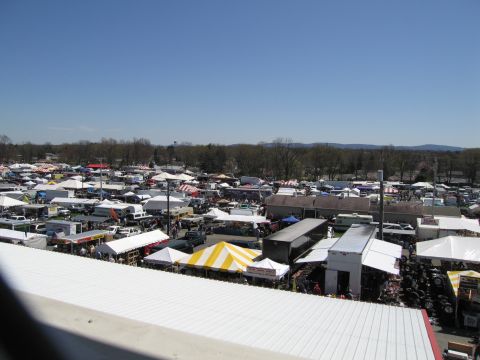 1991 Ford LTD Crown Victoria - A wide view of an outdoor market, showing many vendors and vehicles spread across the area.