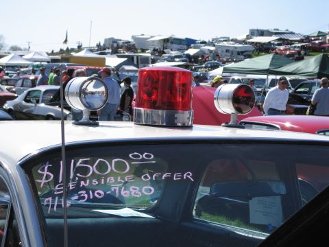 1991 Ford LTD Crown Victoria - Car for sale at an outdoor event, with a police light bar and a handwritten sign on the window.