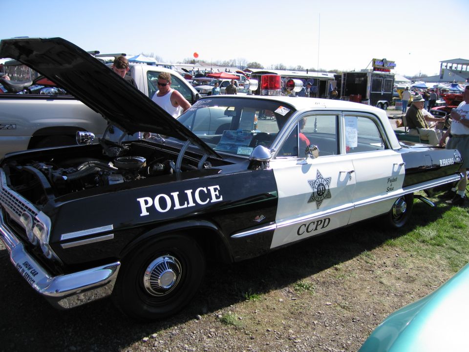 Black and white police car with hood open, showing engine. "POLICE" and "CCPD" text visible
